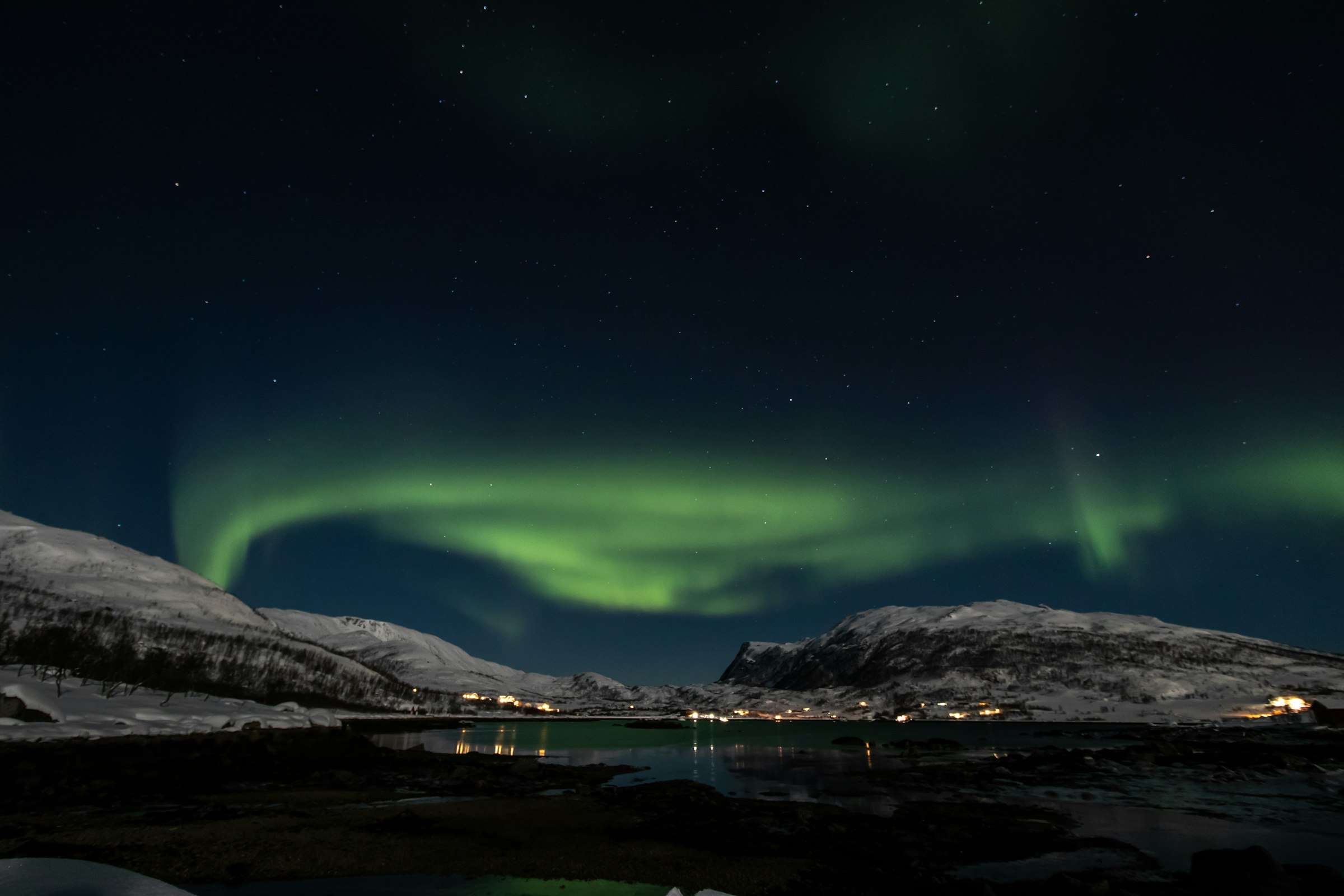 Aurora borealis above a mountain and a still fjord