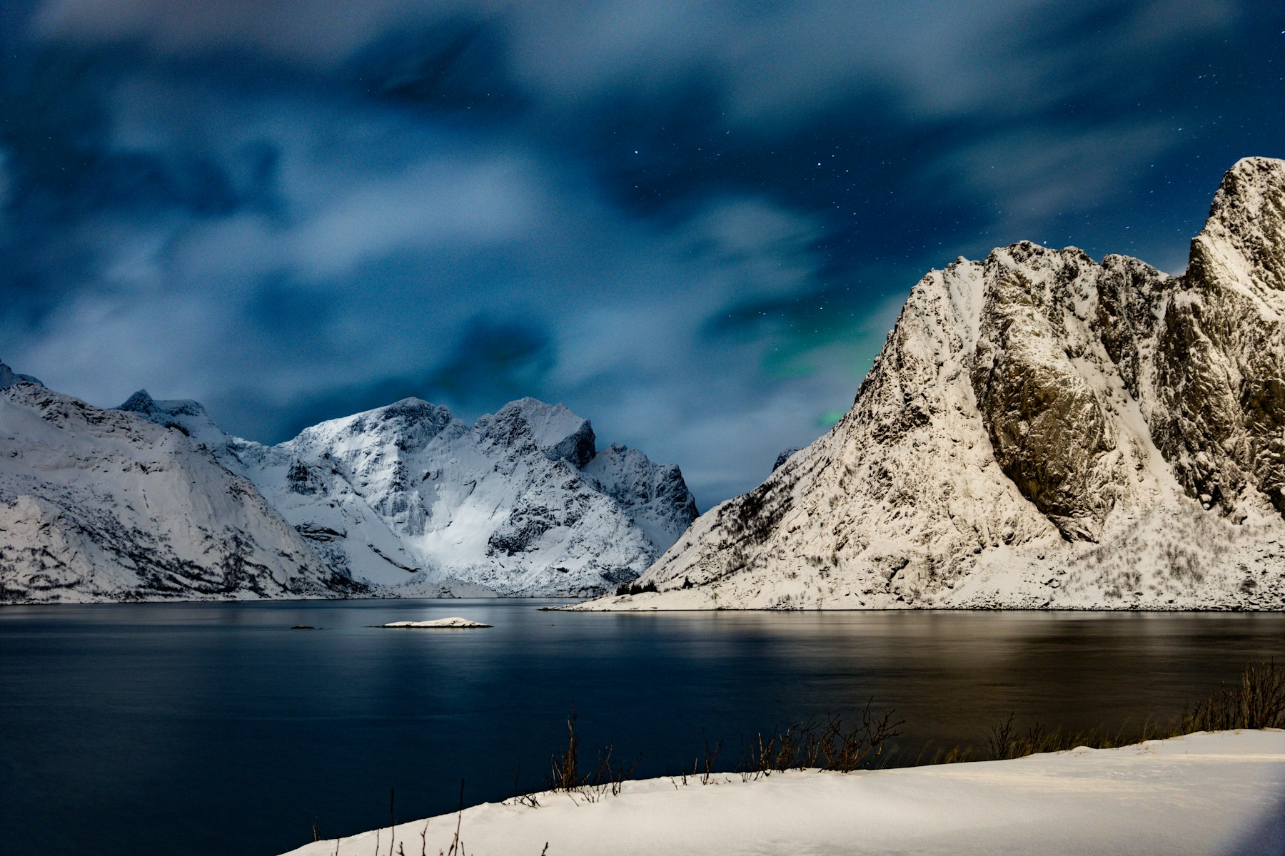 Snow-covered mountains beneath the northern lights